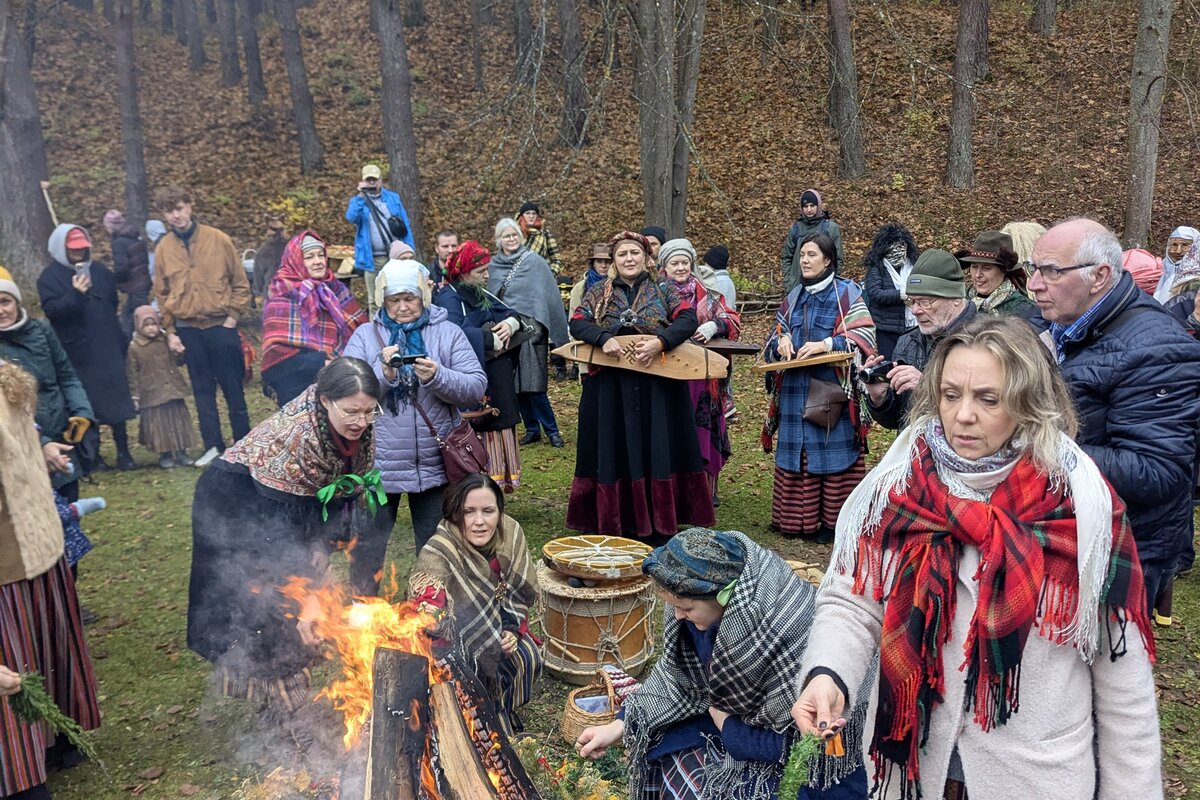 Goście w strojach ludowych wokół ogniska Mārtiņdiena w łotewskim skansenie etnograficznym, Ryga.