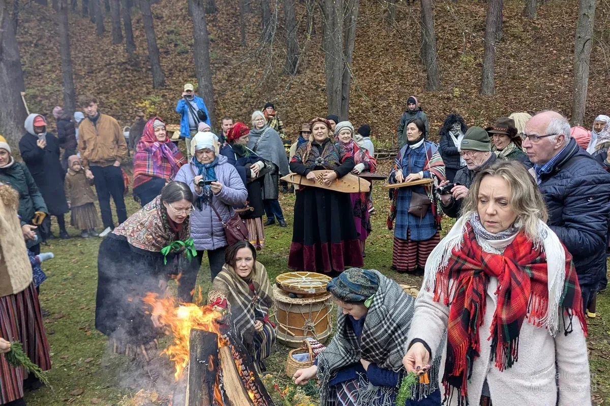Goście w strojach ludowych wokół ogniska Mārtiņdiena w łotewskim skansenie etnograficznym, Ryga.
