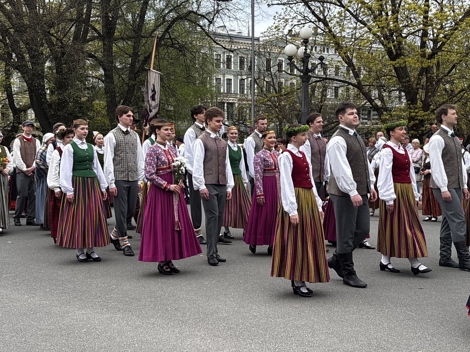 Warta honorowa Armii Łotewskiej przy Pomniku Wolności ze ścianą kwiatów ułożonych u podstawy, Ryga, w Dzień Przywrócenia Niepodległości