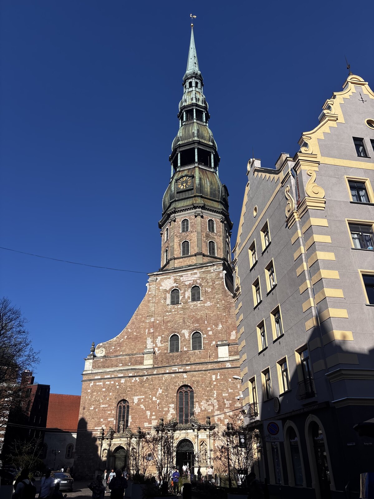 St Peter's Church (Sv. Pētera baznīca) with its tall green spire against a blue sky in Riga Old Town, Latvia.