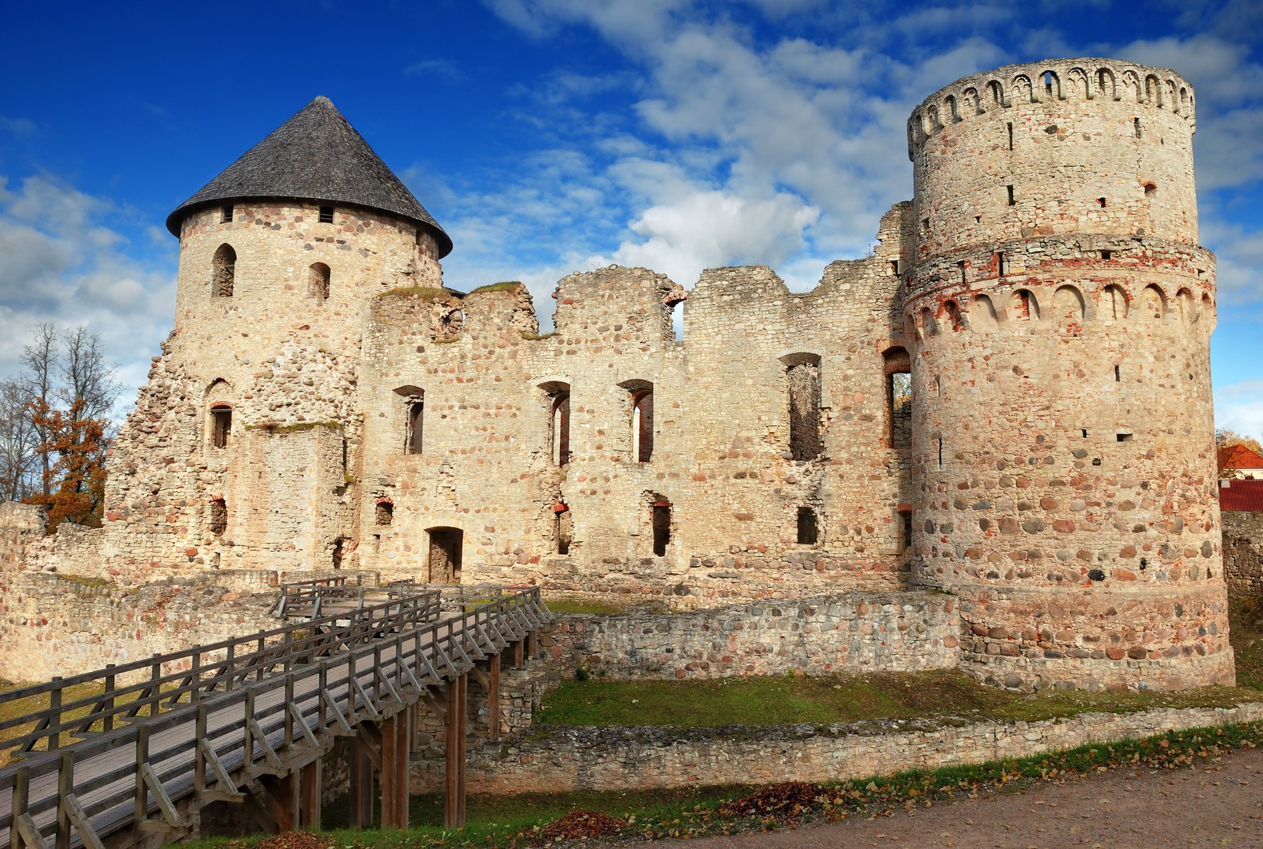 Mury średniowiecznych ruin zamku w Cēsis, czerwona cegła w jesiennym świetle, Łotwa