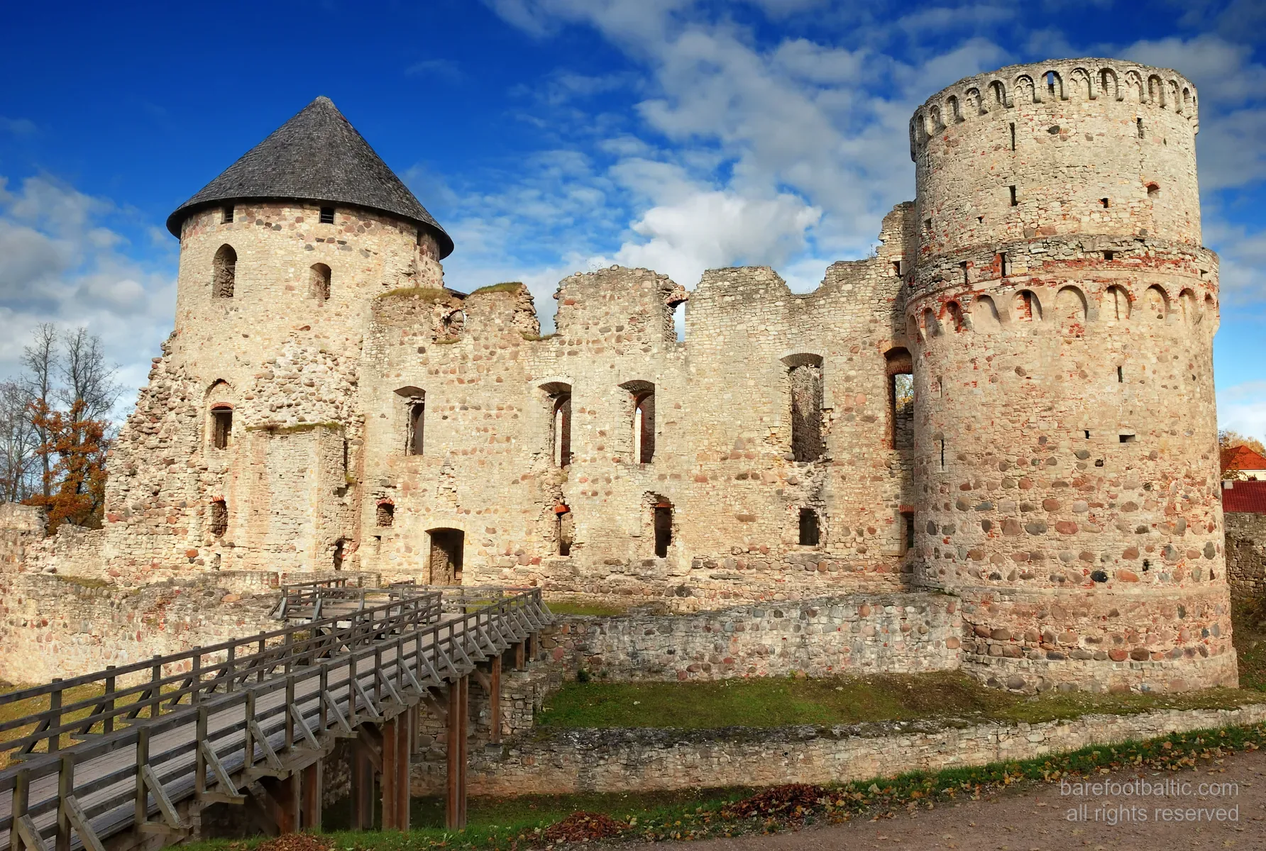 Mury średniowiecznych ruin zamku w Cēsis, czerwona cegła w jesiennym świetle, Łotwa