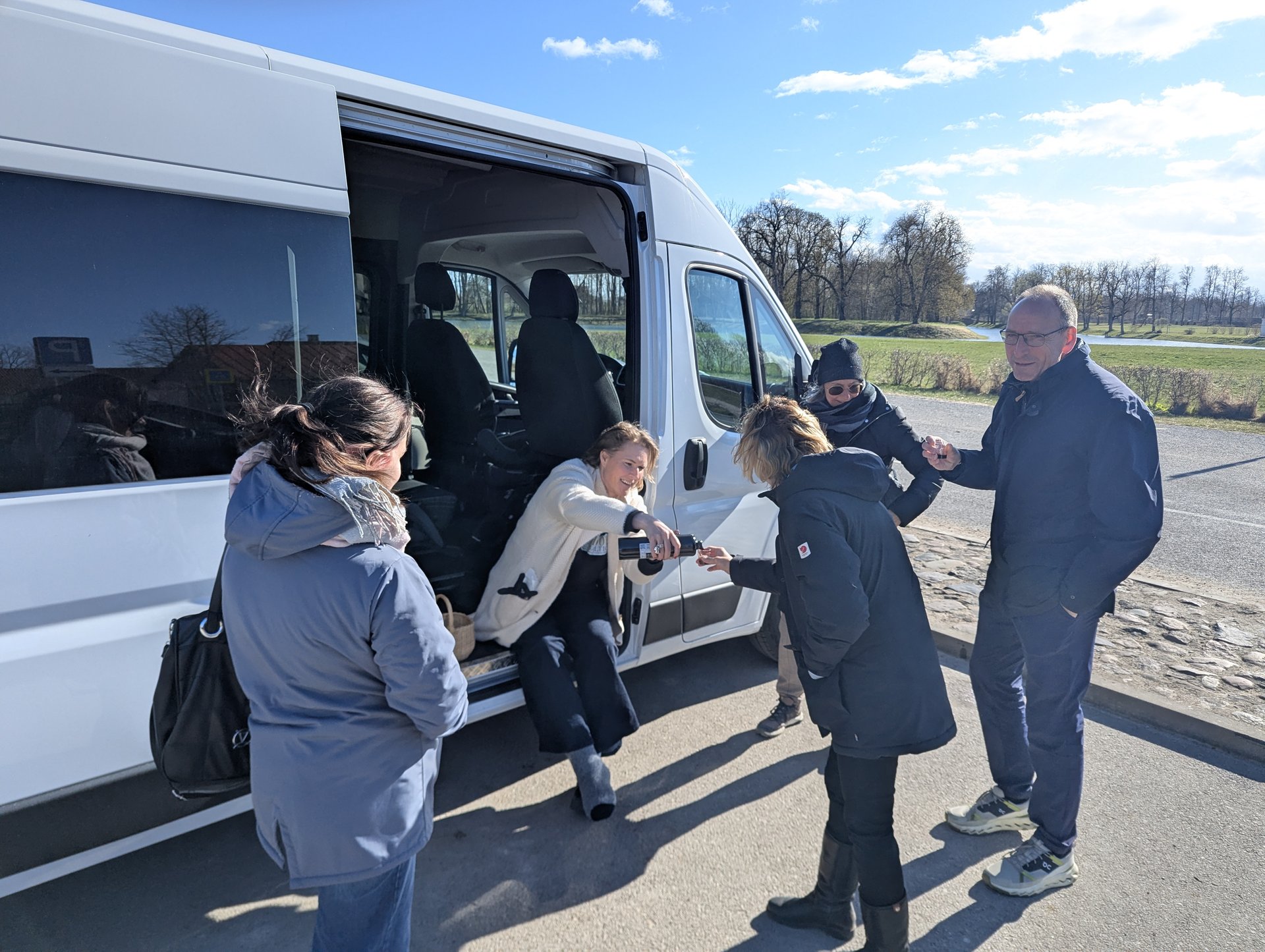 Daiga podająca degustację przy bocznych drzwiach busa Barefoot Baltic