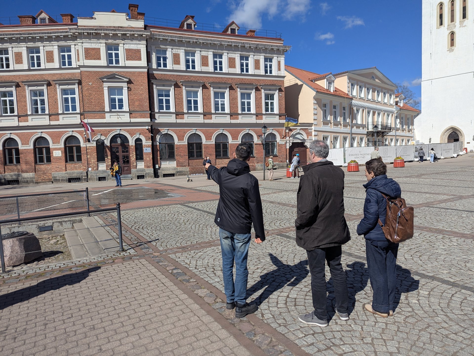 Spacer po starym mieście Cēsis, przewodnik wskazujący zabytkowy budynek